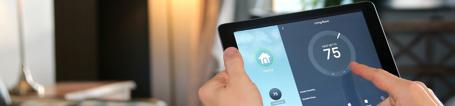 Adjusting the temperature using a tablet with smart home app in modern living room