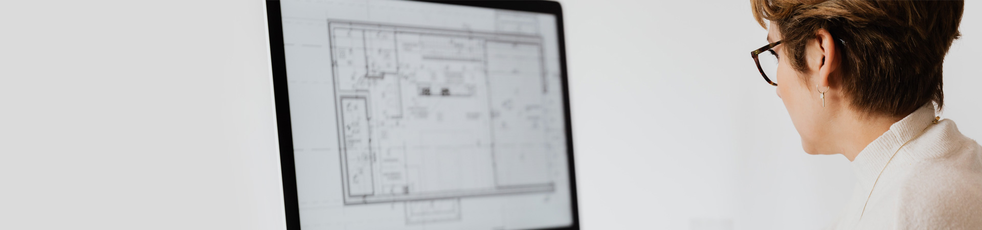 Woman working on floor plan on computer